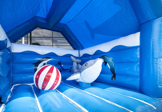 Buy indoor multifun blue bounce house with slide in a dolphin theme with large 3D objects on top for children. Order bounce houses online at JB Inflatables America