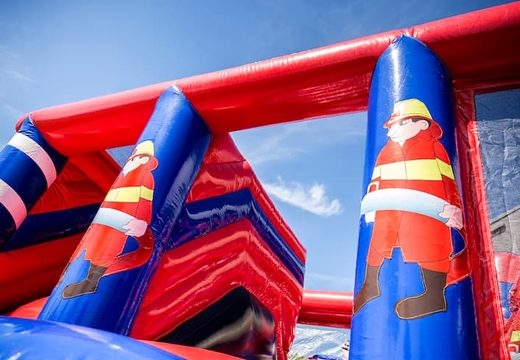 Inflatable covered bounce house in the theme of a fire department with a slide on the jumping surface, climbing tower and fun obstacles for kids. Buy bounce houses online at JB Inflatables America 