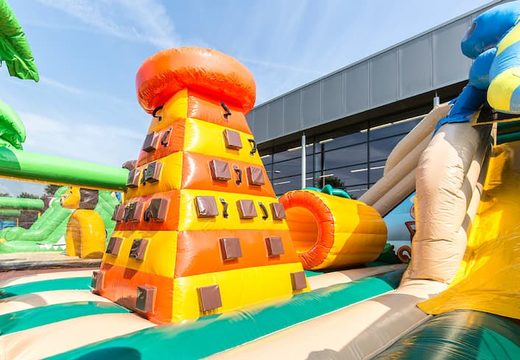 Colored inflatable park in jungle theme with slides, 3D objects, crawl tunnel and climbing tower for children. Buy bounce houses online at JB Inflatables America