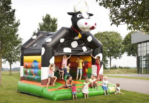 Standard bounce houses for sale in striking colors with a large 3D object of a cow on top, for children. Buy indoor bounce houses online at JB Inflatables America