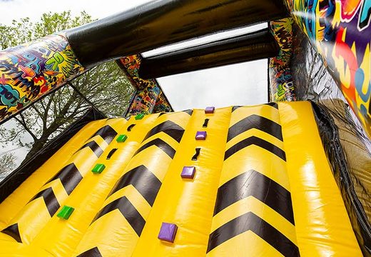 Climbing on bouncy castle with graffiti theme